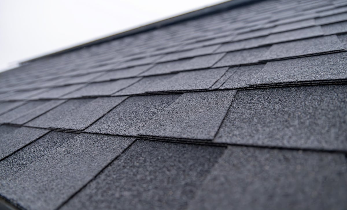 Close-up of dark gray asphalt roof shingles during a roof condition inspection